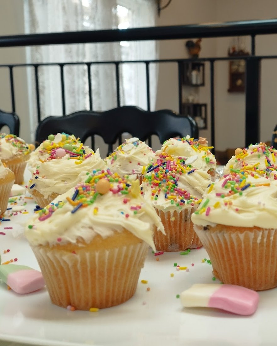 Cupcakes on the counter at Aon Scéal? Café, with the wrought-iron mezzanine rail behind