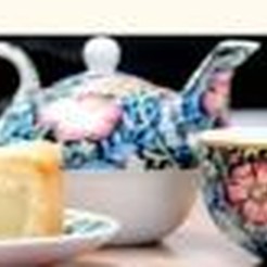 A floral teapot and cup with a wedge of tart, from Aon Scéal? Café's own flyer