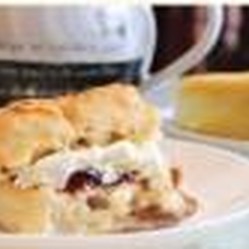 A scone with jam and cream beside a slice of cake, from Aon Scéal? Café's own flyer
